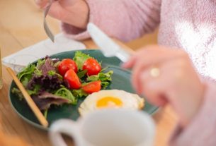 Enjoy a nutritious breakfast with greens, fried egg, and fresh orange juice for a healthy start to your day.